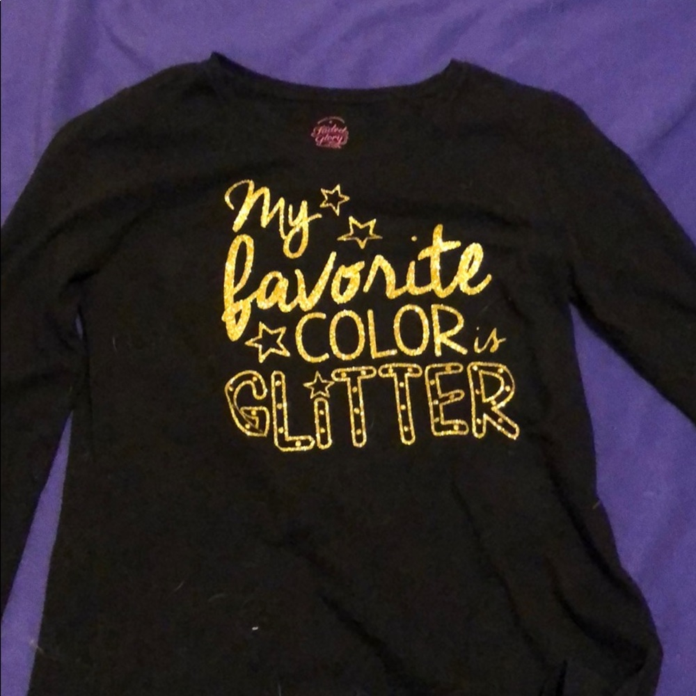 a child’s long sleeve with gold lettering details.